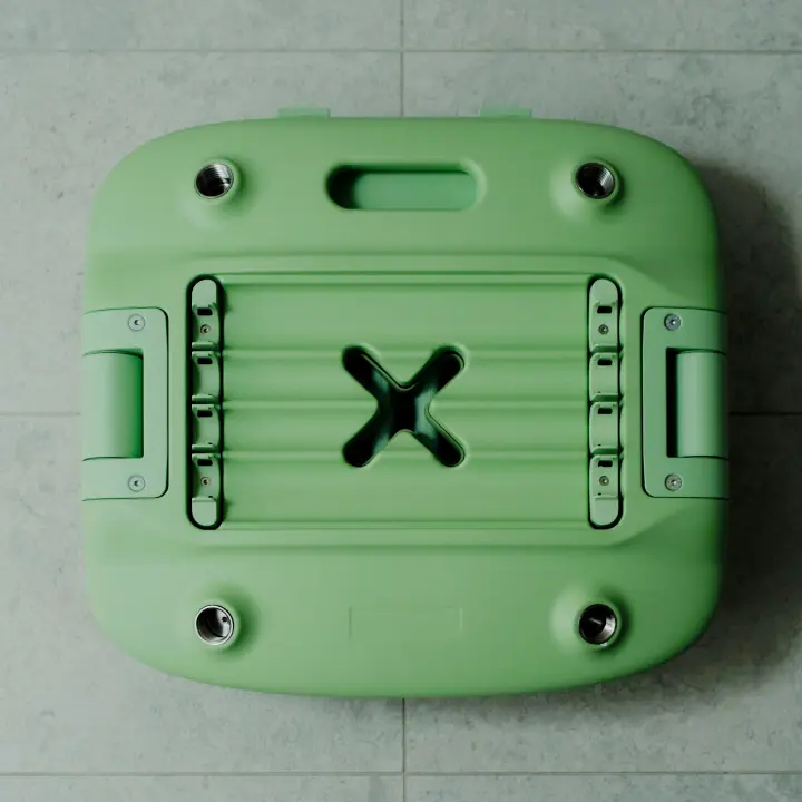 A pastel Oasis Shower Chair is shown in its packed down form. The height adjustable leg storage compartment is visible on the underside of the chair. The chair is folded and packed down, ready for the telescopic legs to be packed for storage or transport