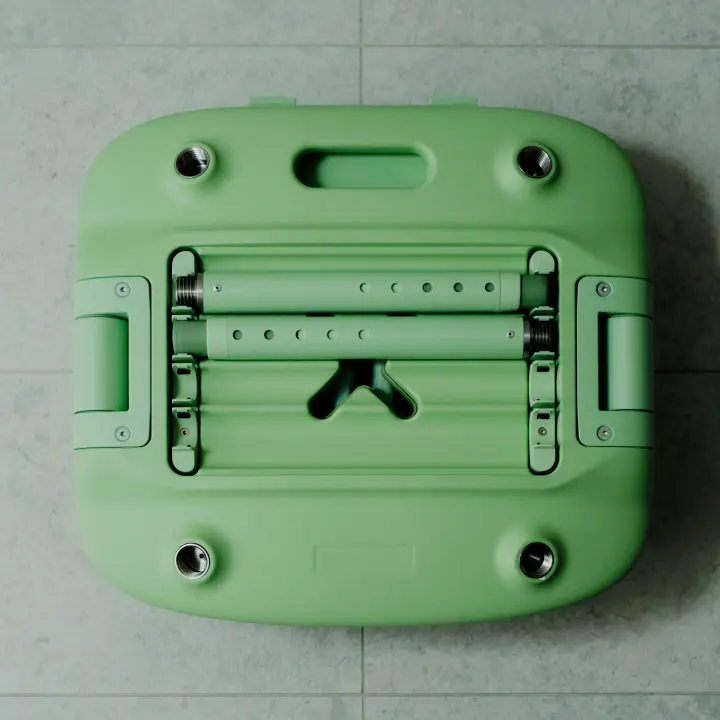 A pastel green Oasis Chair is shown in its packed down form. Two telescopic legs are fitted into the storage compartment on the underside of the chair. The chair is folded and packed down, ready for storage or transport