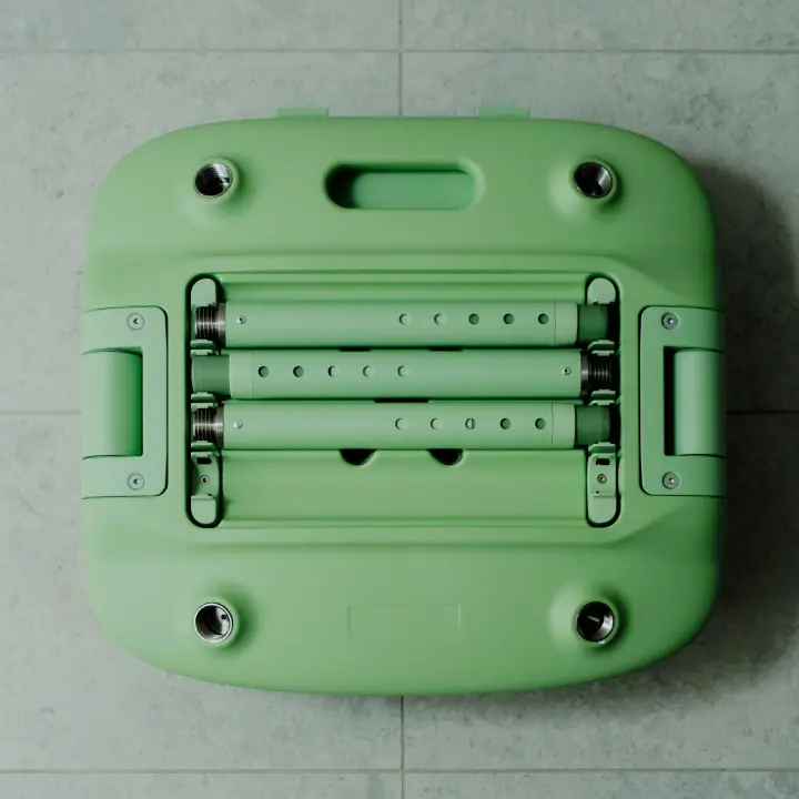 A pastel green Oasis Shower Chair is shown in its packed down form. Three telescopic legs are fitted into the storage compartment on the underside of the chair. The chair is folded and packed down, ready for storage or transport