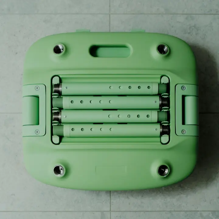 A pastel green Oasis Shower Chair is shown in its packed down form. Four telescopic legs are fitted into the storage compartment on the underside of the chair. The chair is folded and packed down, ready for storage or transport