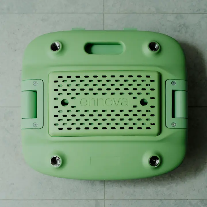 A pastel green Oasis Shower Chair is shown in its packed down form. The chair is folded and packed down, ready for storage or transport