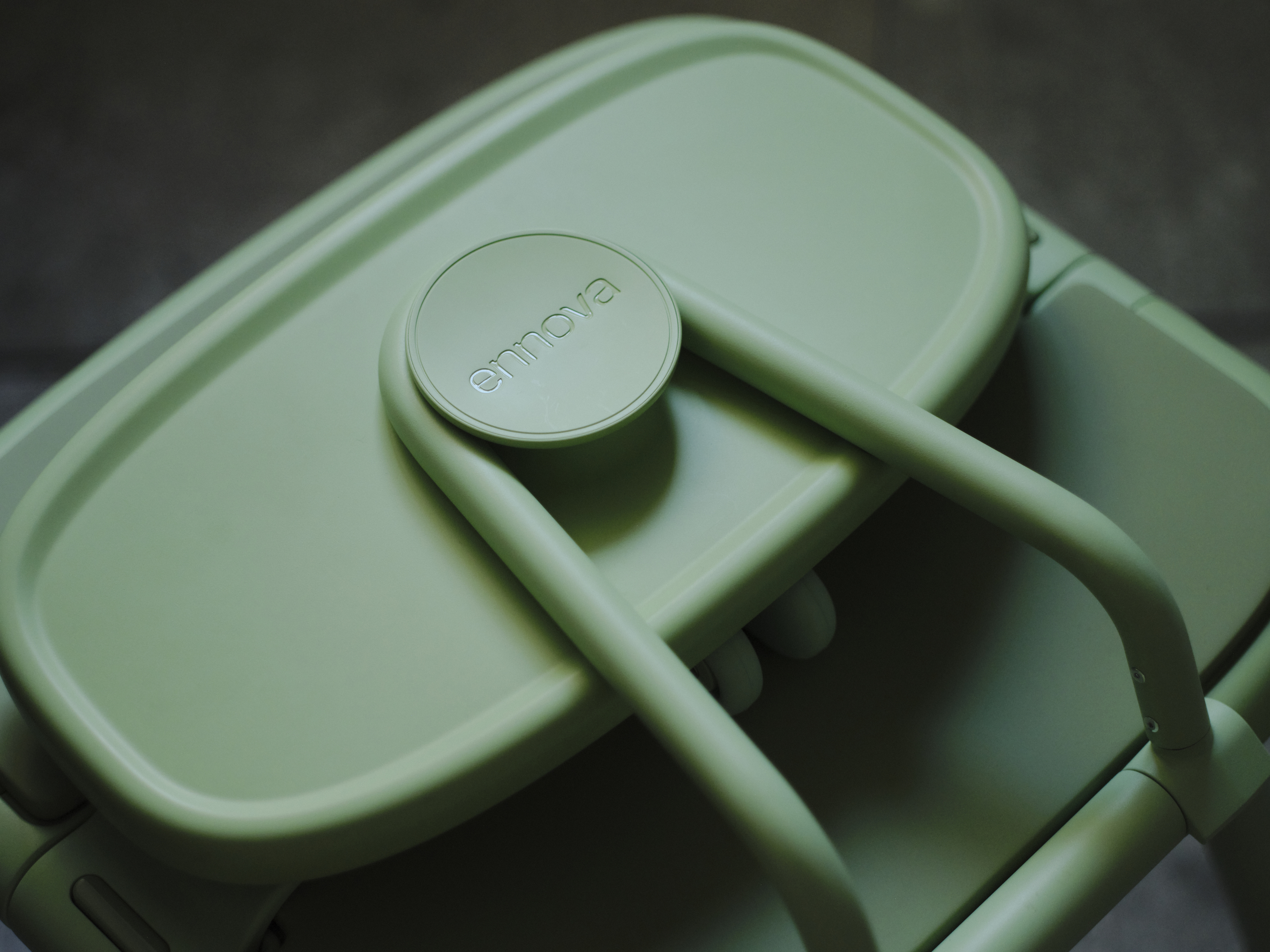 Oasis Shower Chair detail image. The green foldable backrest has been packed down and the ennova logo is visible