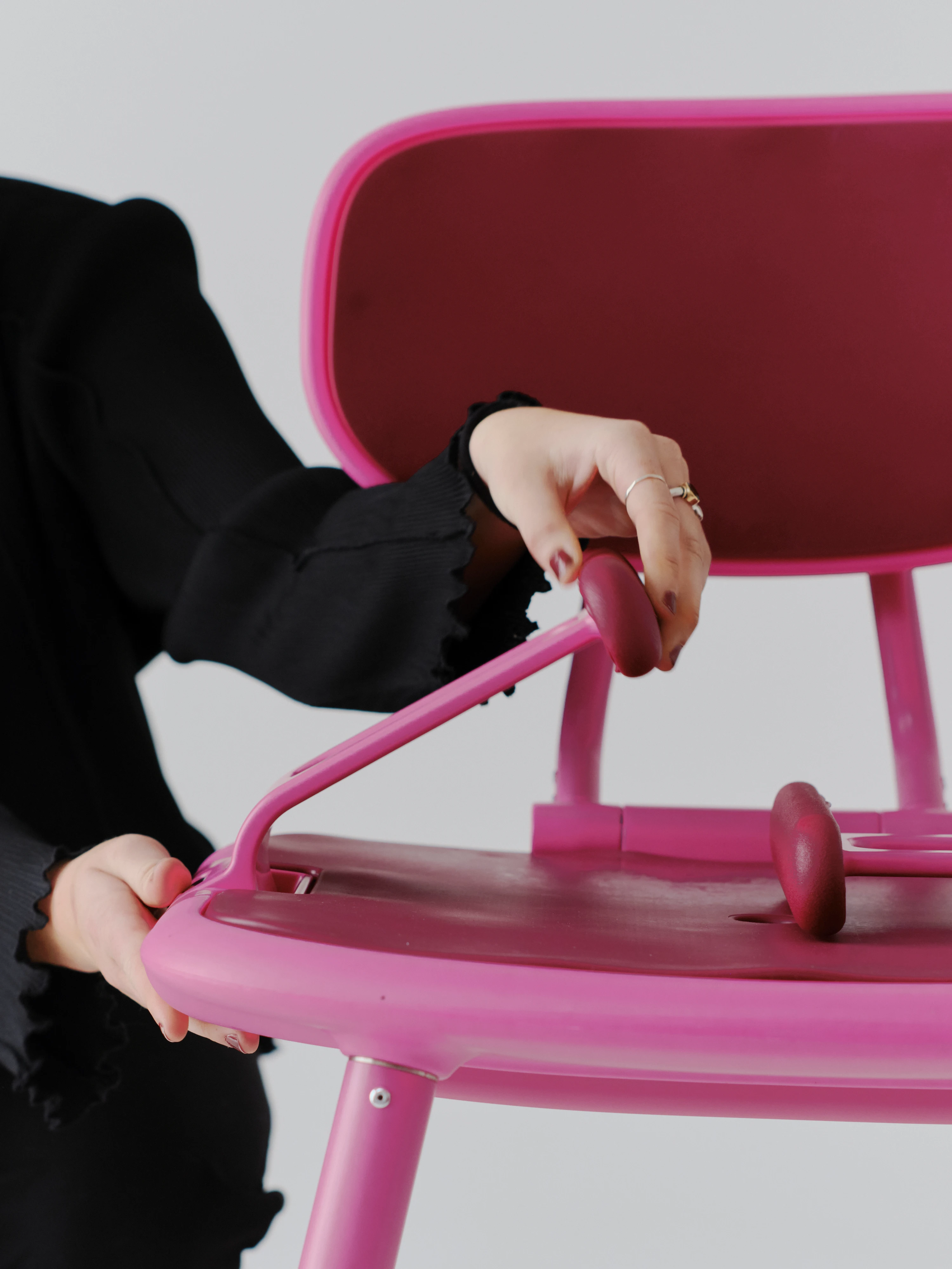 Action shot of woman using the bi-directional armrests on the Bottlebrush Pink Oasis Shower Chair.